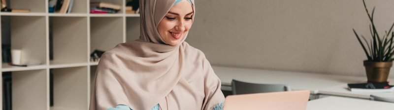 young-pretty-modern-muslim-woman-hijab-working-laptop-office-room-education-online